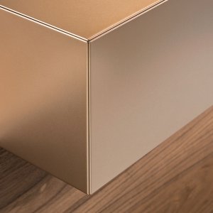 Plate i valnøtt og sider i kobber metallic på resepsjonsdisken Toki